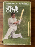 Vintage hardcover book of Norman O'Neill's 'Ins & Outs' featuring a cricket player on the cover, placed on a wooden surface.